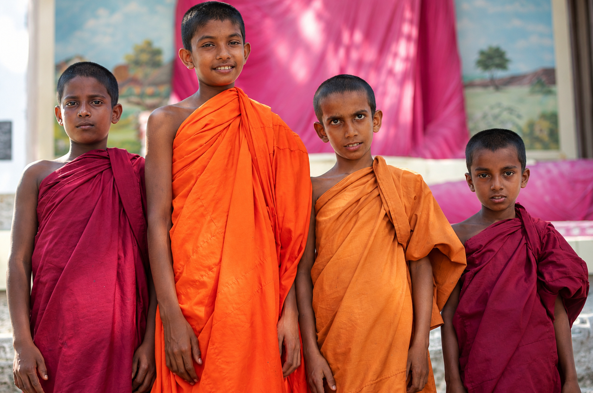 Vier junge Mönche in einem buddhistischem Tempel in Ambalangoda auf Sri Lanka.